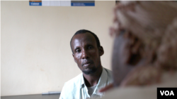 Ibrahim Hussein, a father of seven, is taken through the repatriation by an UNHCR representative, Dadaab, Kenya, April 27, 2015. (Mohammed Yusuf/VOA).