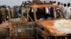 Des responsables nigériens se tiennent près de la voiture du groupe humanitaire français ACTED dans la réserve de Kouré, à environ 60 km de Niamey, le 21 août 2020.