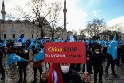 A protester from the Uyghur community living in Turkey, holds an anti-China placard during a protest in Istanbul, March 25, against the visit of China's FM Wang Yi to Turkey.