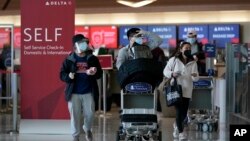 អ្នក​ធ្វើ​ដំណើរ​ដើរ​នៅ​ក្នុង​អាកាសយានដ្ឋាន​អន្តរជាតិ​ក្រុង San Francisco សហរដ្ឋ​អាមេរិក​ ក្នុង​អំឡុង​មាន​ការ​រាតត្បាត​នៃ​ជំងឺ​កូវីដ១៩ កាល​ពី​ថ្ងៃ​ទី​២២ ខែ​ធ្នូ​ ឆ្នាំ​២០២០។