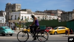 FILE - A cyclist wears a face mask amid the coronavirus pandemic in Havana, Cuba, Aug. 10, 2020.