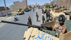 FILE - Afghan National Army commando forces stand guard along a road amid ongoing fighting between Taliban and Afghan security forces in the Enjil district of Herat province, August 1, 2021.