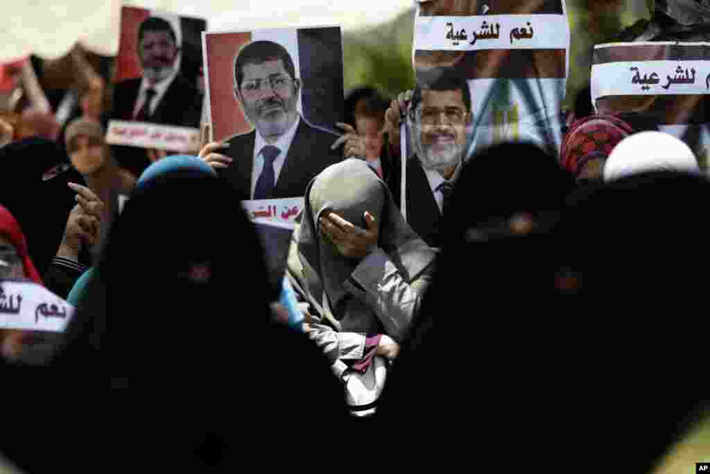 A supporter of ousted Egypt&#39;s President Mohamed Morsi cries during a protest near the University of Cairo, Giza, Egypt, Friday, July 5, 2013. Arabic reads, &quot;Yes for the legitimacy.&quot; Egypt&#39;s Muslim Brotherhood called for a wave of protests Friday, furious over the military&#39;s ouster of its president and arrest of its revered leader and other top figures, raising fears of violence and retaliation from Islamic militants.