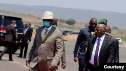 Rais wa Uganda Yoweri Museveni (kushoto) na rais wa Tanzania John Magufuli (kulia) wakielekea katika mojawapo ya vikao kuhusu ujenzi wa bomba la mafuta kutoka Hoima hadi Tanga