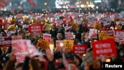 Para pengunjuk rasa meneriakkan slogan dalam aksi protes yang menuntut Presiden Park Geun-hye untuk turun dari jabatannya di Seoul, Korea Selatan (19/11).
