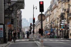 A man rides his bike in an empty street during a nationwide confinement to counter the COVID-19 in Paris, April 21, 2020.