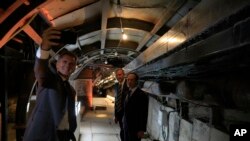 Para tamu berswafoto di terowongan kuno dalam pempukaan jalan kuno ke Kota Daud, sebuah lokasi arkeologi dan wisata populer di kawasan Silwan yang dihuni warga Palestina di timur Yerusalem, 30 Juni 2019. (Foto: AP)