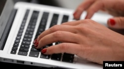 A person types on a laptop computer in Manhattan, New York City