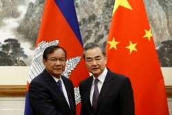 រូបឯកសារ៖ រដ្ឋមន្ត្រីការបរទេសកម្ពុជាលោក ប្រាក់ សុខុន និងរដ្ឋមន្ត្រីការបរទេសចិនលោក Wang Yi ថត​រូបរួមគ្នានៅវិមានរដ្ឋាភិបាល Diaoyutai ប្រចាំទីក្រុងប៉េកាំង ប្រទេសចិន កាលពីថ្ងៃទី៣១ ខែឧសភា ឆ្នាំ២០១៩។