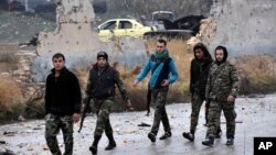 This photo released by the Syrian official news agency SANA, shows Syrian troops and pro-government gunmen marching through the streets of east Aleppo, Syria, Dec. 13, 2016. 