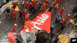 Tim SAR melambaikan tangan pada helikopter Angkatan Udara dekat bagian pesawat AirAsia bernomor penerbangan 8501 setelah diangkat dari dasar laut (10/1). (AP/Prasetyo Utomo)