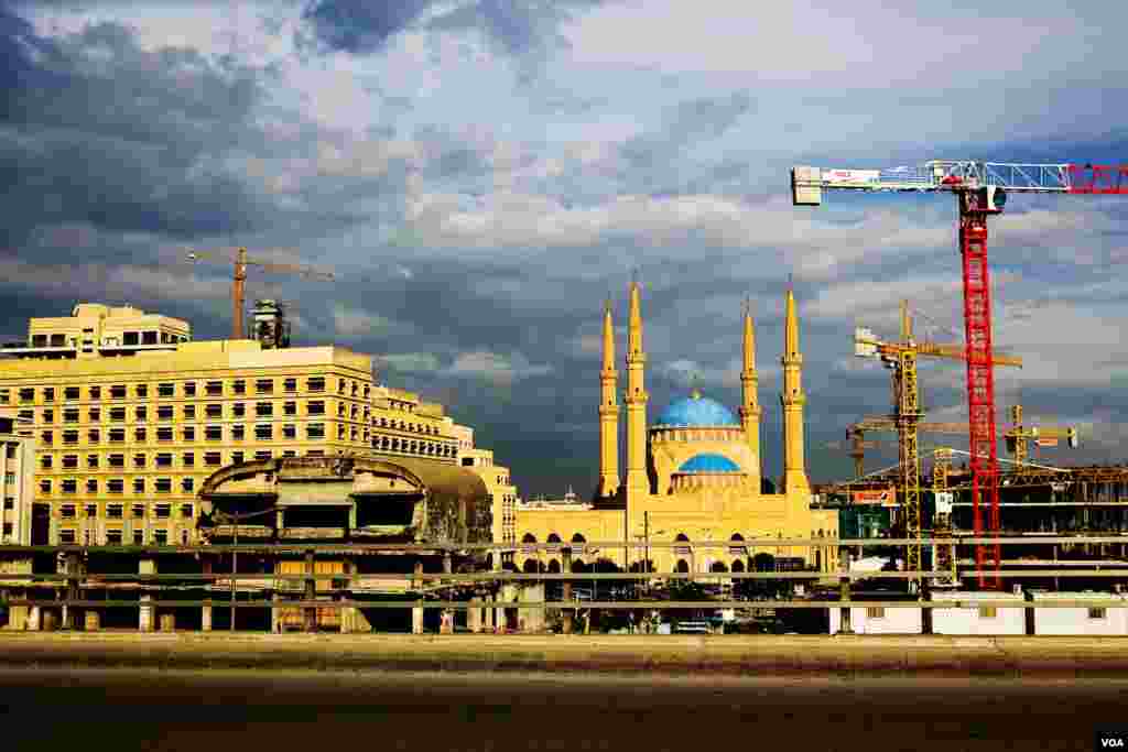 Construction cranes and a bombed out, egg-shaped movie theater near the blue domed Mohammad Al-Amin Mosque, which was completed in 2007. (VOA/V. Undritz)