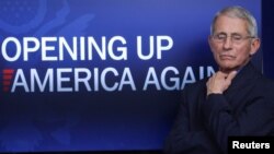 លោក​វេជ្ជបណ្ឌិត Anthony Fauci​ ឈរ​នៅ​ពី​មុខ​ឃ្លា​មួយ​សរសេរ​ថា «បើក​សកម្មភាព​សេដ្ឋកិច្ច​នៅ​ក្នុង​សហរដ្ឋអាមេរិក​ម្ដង​ទៀត» នៅ​សេតវិមាន ថ្ងៃ​ទី​១៦ ខែមេសា ឆ្នាំ​២០២០។