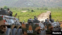 ទាហាន​ចិន​អង្គុយ​លើ​រថពាសដែក​ ខណៈ​ដែល​ពួកគេ​ចូល​រួម​ក្នុង​ការ​ពិធី​បើក​ការ​ធ្វើ​សមយុទ្ធ​យោធា​រួម​គ្នា​ជាមួយ​នឹង​កម្ពុជា​ក្នុង​ខេត្ត​កំពង់ស្ពឺ កាល​ពី​ថ្ងៃ​ទី​១៧ ខែ​មីនា ឆ្នាំ​២០១៨។ 