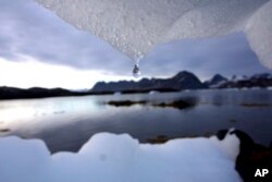 FILE - An iceberg melts in Kulusuk, Greenland near the arctic circle. A new report finds permafrost in the Arctic is thawing faster than ever before.