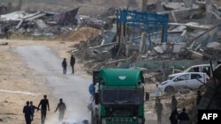 Wapalestina wakiharakisha kuchukua maji yaliyodondoka kutoka katika lori lililokuwa limebeba msaada wa kinadamu wakati likipita eneo la Rafah huko kusini mwa Ukanda wa Gaza, Februaryi 18, 2025.