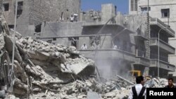 Civilians and members of the Free Syrian Army inspect a damaged building in al-Kalaseh neighbourhood in Aleppo, after a morning jet air strike, September 19, 2012. 