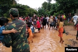 Villagers carry their belongings as they evacuate after the Xepian-Xe Nam Noy hydropower dam collapsed in Attapeu province, Laos, July 24, 2018.