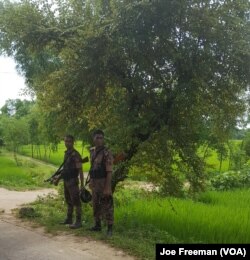 Bangladeshi soldiers stand beside the road leading to Kutupalong refugee camp in Bangladesh, Oct. 6, 2017.