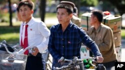 지난해 10월 북한 평양 거리에서 주민들이 자전거를 끌고 횡단보도를 건너고 있다. (자료사진)