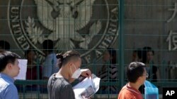 北京驻北京使馆前排队等候申请赴美签证的人。(2018年7月26日)