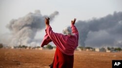 13일 터키 쪽 접경 마을인 수루크에서 바라본 시리아 쿠르드 거점 코바니에서 연합군 공습에 의한 것으로 보이는 연기가 피어오르고 있다.