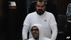 លោក Mohammed Soltan ត្រូវបានរុញ​ដោយ ឪពុករបស់លោកឈ្មោះ Salah ក្នុងអំឡុងពេល បង្ហាញខ្លួនក្នុងតុលាការមួយ នៅក្នុងទីក្រុង Le Caire ប្រទេសអេហ្ស៊ីបនាថ្ងៃទី០៩ ខែមិនា ឆ្នាំ២០១៥។