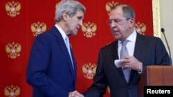 Menlu AS John Kerry (kiri) menjabat tangan Menlu Sergei Lavrov pada acara konferensi pers bersama di Moskow, Rusia 15 Desember 2015 (foto: dok).