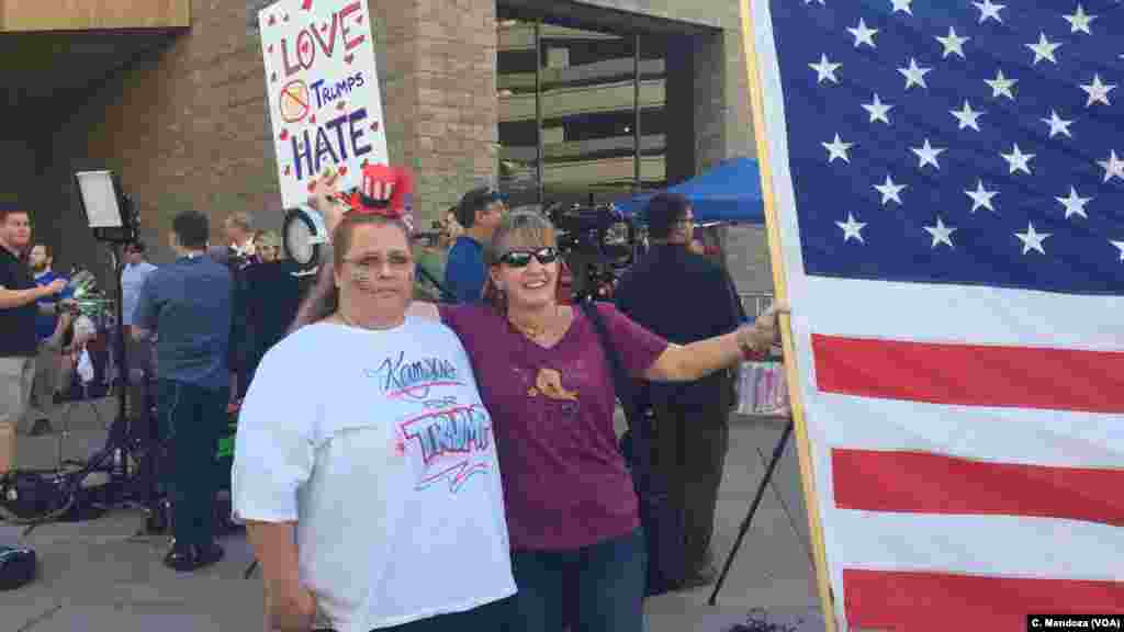 Two women from Kansas traveled to President Donald Trump's campaign-style rally in Phoenix, Aug. 22, 2017. The woman on the left supports Trump; the woman on the right is against his rhetoric.