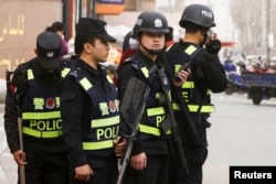 FILE - Armed police keep watch in a street in Kashgar, Xinjiang Uighur Autonomous Region, China, March 24, 2017.