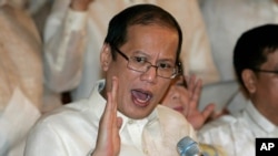 FILE - In this June 30, 2010, photo, then newly inaugurated Philippine President Benigno Aquino III, center, swears in local officials during his first day at the Malacanang presidential palace in Manila, Philippines. 
