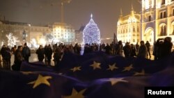 People hold a big European Union flag during a protest against a proposed new labor law, billed as the "slave law," in front of the Parliament building in Budapest, Hungary, Dec. 18, 2018. 