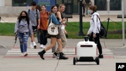 Robot pengantar makanan melintasi jalan di Ann Arbor, Michigan pada Kamis, 7 Oktober 2021. (Foto: AP/Carlos Osorio)
