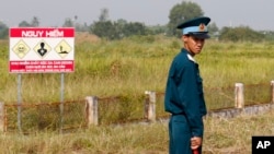 Seorang tentara Vietnam berdiri di dekat lokasi pada Perang Vietnam yang digunakan untuk menyimpan bahan kimia yang sangat berbahaya, “agen oranye.” (foto: ilustrasi). 