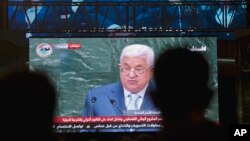 FILE - Palestinians follow President Mahmoud Abbas' speech at the annual U.N. General Assembly, on a large screen in the West Bank city of Ramallah, Sept. 27, 2018. 