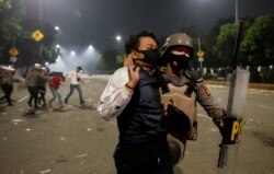 Seorang polisi menahan seorang demonstran dalam unjuk rasa menentang UU Cipta Karya di Jakarta (foto: ilustrasi).