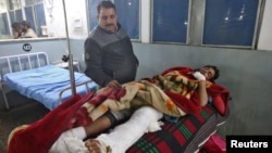 Rođak posmatra ranjene noge Muhameda Junisa, civila, koji je ranjen u prekograničnim borbama u blizini Linije kontrole u sektoru Punč, 1. marta 2019, u bolnici u Đamuu.