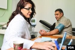 A doctor tends to a visitor at the UNRWA clinic in southern Beirut, one of 27 UNRWA funded clinics in Lebanon. (J. Owens/VOA)