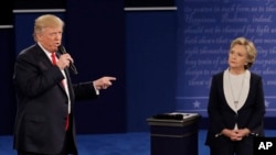 Republican presidential nominee Donald Trump speaks to Democratic presidential nominee Hillary Clinton during the second presidential debate at Washington University in St. Louis, Sunday, Oct. 9, 2016. 