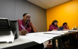 Tnisha Nation, left, Sandrea Guerrero, center, and Elena Mojica reach out to families in the San Antonio Independent School District, Tuesday, June 8, 2021, in San Antonio. (AP Photo/Eric Gay)