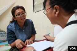 អ្នកស្រី ឡុង គឹមហ៊ាង ភរិយាលោក រ៉ាត់ រត្នមុនី អ្នកបកប្រែភាពយន្តឯកសារ «ម្តាយខ្ញុំ លក់ខ្ញុំ» កំពុងបង្រៀនភាសាអង់គ្លេសដល់អ្នកជិតខាង ខណៈកំពុងស្ថិតក្នុងបន្ទប់ជួលមួយក្នុងប្រទេសដែលអ្នកស្រីកំពុងភៀសខ្លួន នៅថ្ងៃទី២៤ ខែកញ្ញា ឆ្នាំ២០១៩។ (កាន់ ​វិច្ឆិកា/VOA)