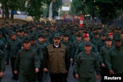 FILE - Venezuela's President Nicolas Maduro walks next to Venezuela's Defense Minister Vladimir Padrino Lopez and Remigio Ceballos, Strategic Operational Commander of the Bolivarian National Armed Forces, during a ceremony at a military base in Caracas, Venezuela, May 2, 2019.