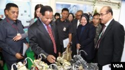Attendees at the 3R Forum look at toy motorcycles made from recycled parts, Surabaya, Indonesia. (Petrus Riski/VOA)