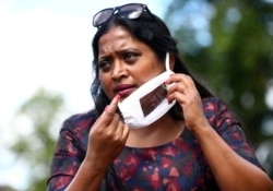 FILE - Director of Empowering Deaf Society Mangai Sutharsan, puts on a partially transparent mask following the coronavirus disease (COVID-19) outbreak in Ilford, London, Britain, July 29, 2020.