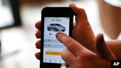 This April 27, 2016, photo, shows a smartphone displaying the Maven app, a General Motors car-sharing service, in Ann Arbor, Mich. Automakers are reinventing themselves as "mobility" companies that can help people get around. Already this year, General Motors Co. announced a long-term agreement with ride-hailing company Lyft and started a car-sharing service called Maven. (AP Photo/Paul Sancya)