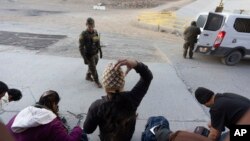 Agent granične patrole gleda kako se migranti pakuju nakon što su ilegalno prešli i čekali da podnose zahtjev za azil između dva granična zida koja razdvajaju Meksiko i Sjedinjene Države, u utorak, 21. januara 2025, u San Diegu. (Foto: AP /Gregory Bull)