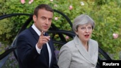 Presiden Prancis Emmanuel Macron dan Perdana Menteri Inggris Theresa May saat tiba untuk berbicara dengan pers di Istana Elysee di Paris, Prancis, 13 Juni 2017.