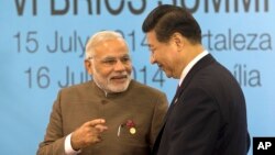 India's Prime Minister Narendra Modi, left, talks with China's President Xi Jinping, after they took their group photo for the BRICS summit in Fortaleza, Brazil, Tuesday, July 15, 2014. The leaders of the BRICS nations, Brazil, Russia, India, China and South Africa, are expected to officially create a bailout and development fund worth $100 billion. It's meant to be an alternative to the World Bank and the International Monetary Fund, which are seen as being dominated by the U.S. and Europe. (AP Photo/Silvia Izquierdo)