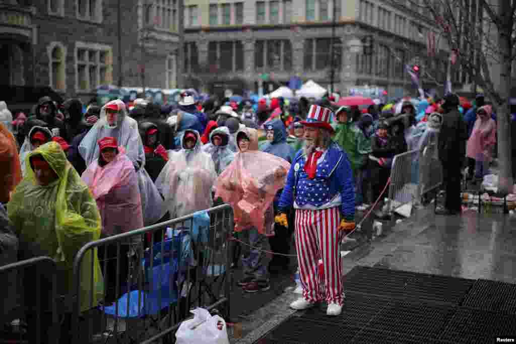 A man dressed as Uncle Sam looks on as supporters line up outside Capital One Arena, ahead of a rally for U.S. President-elect Donald Trump the day before he is scheduled to be inaugurated for a second term, in Washington, Jan. 19, 2025. 