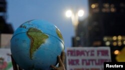 Seseorang memegang bola bumi selama gerakan Global Climate Strike of the Fridays for Future di Sao Paulo, Brazil, 20 September 2019. (Foto: REUTERS/Nacho Doce)